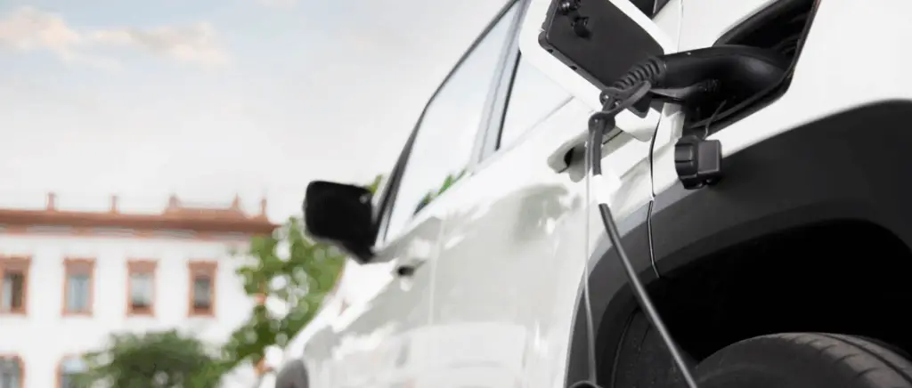 une voiture électrique blanche recharge à l'extérieur