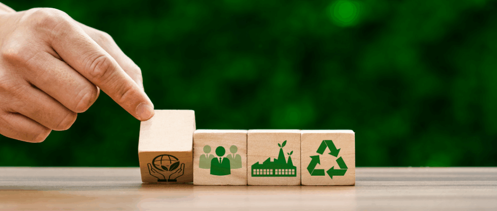 une main en gros plan déplace des cubes en bois sur lesquels apparaissent des icônes de couleur verte qui représentent la transition énergétique