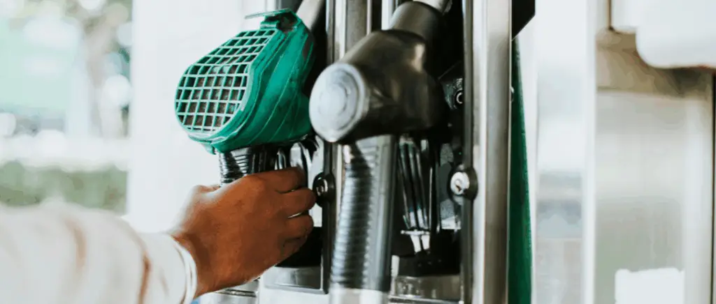 une main en gros plan attrape un pistolet diesel à la station essence